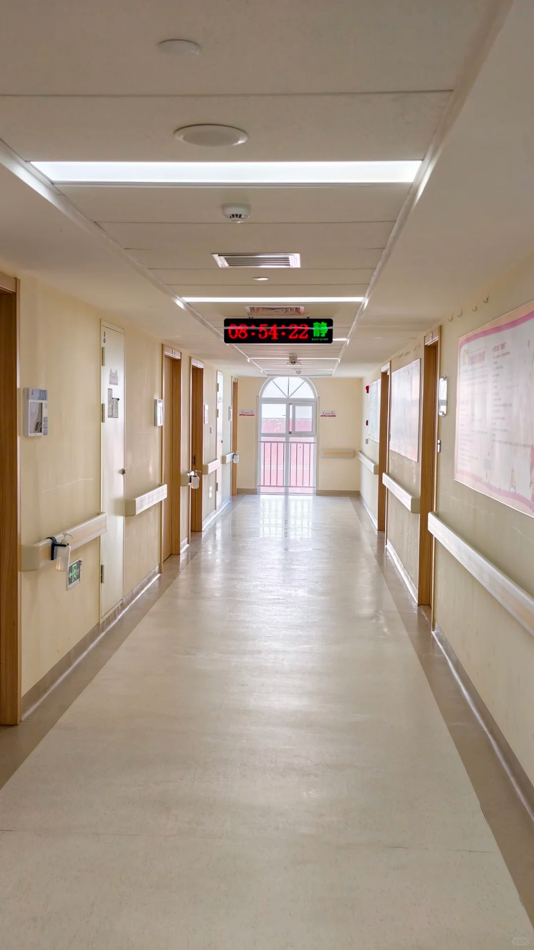 Bright clean corridor at Beijing Boren Hospital with safety handrails and digital clock