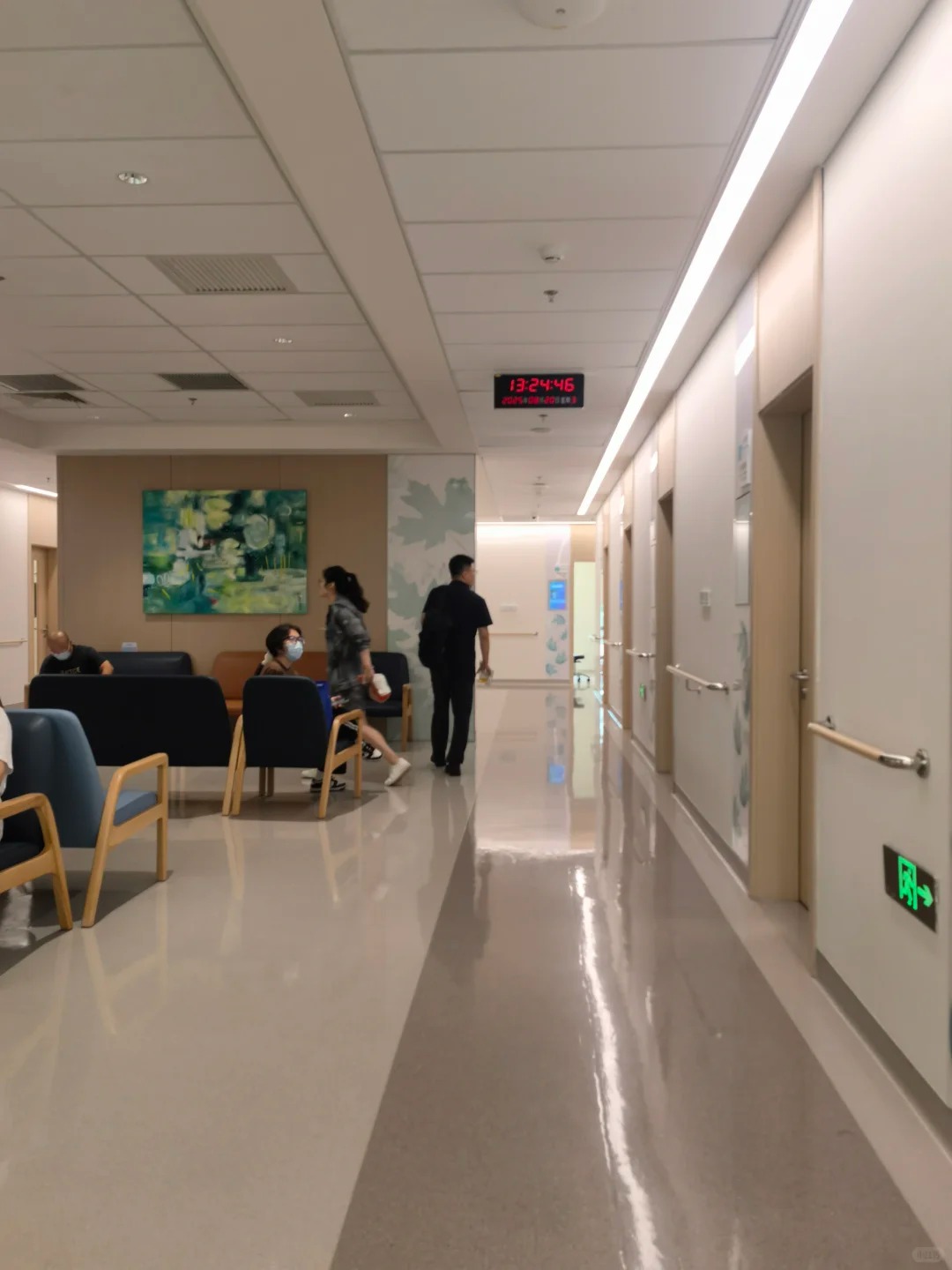 Clean hospital corridor with waiting area and artwork on the wall