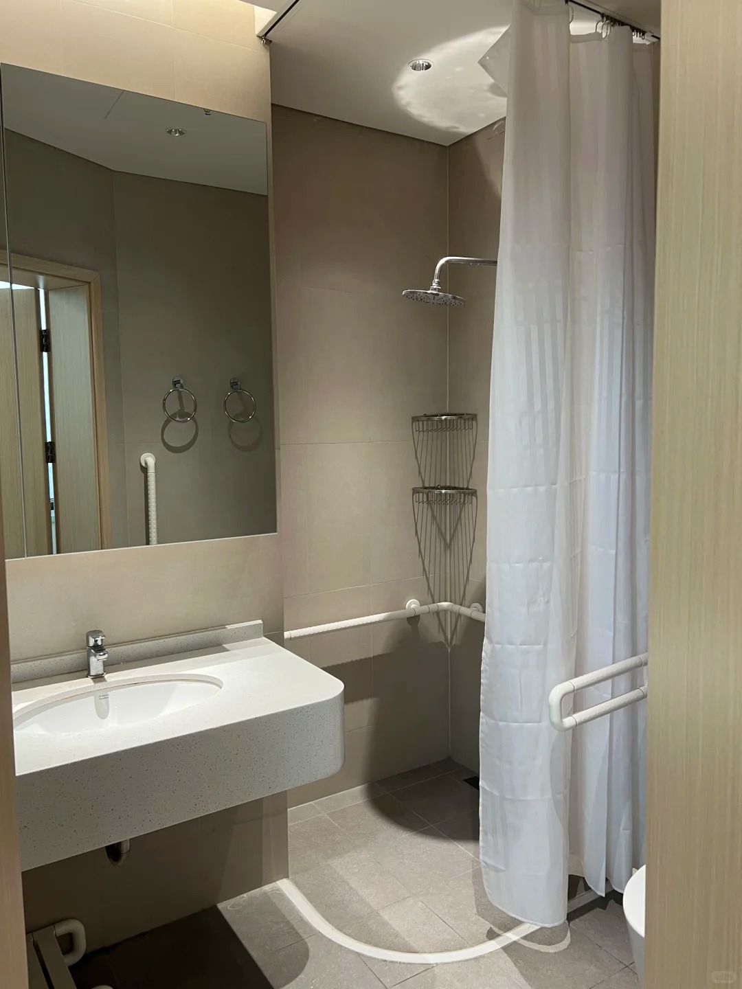 Accessible patient bathroom with grab bars, sink and shower facilities